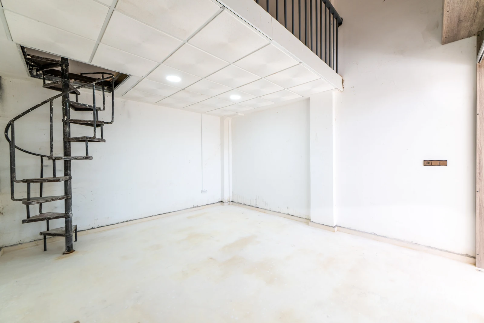 Magasin avec mezzanine et escalier hélicoïdal, vu depuis l'entrée vitrée